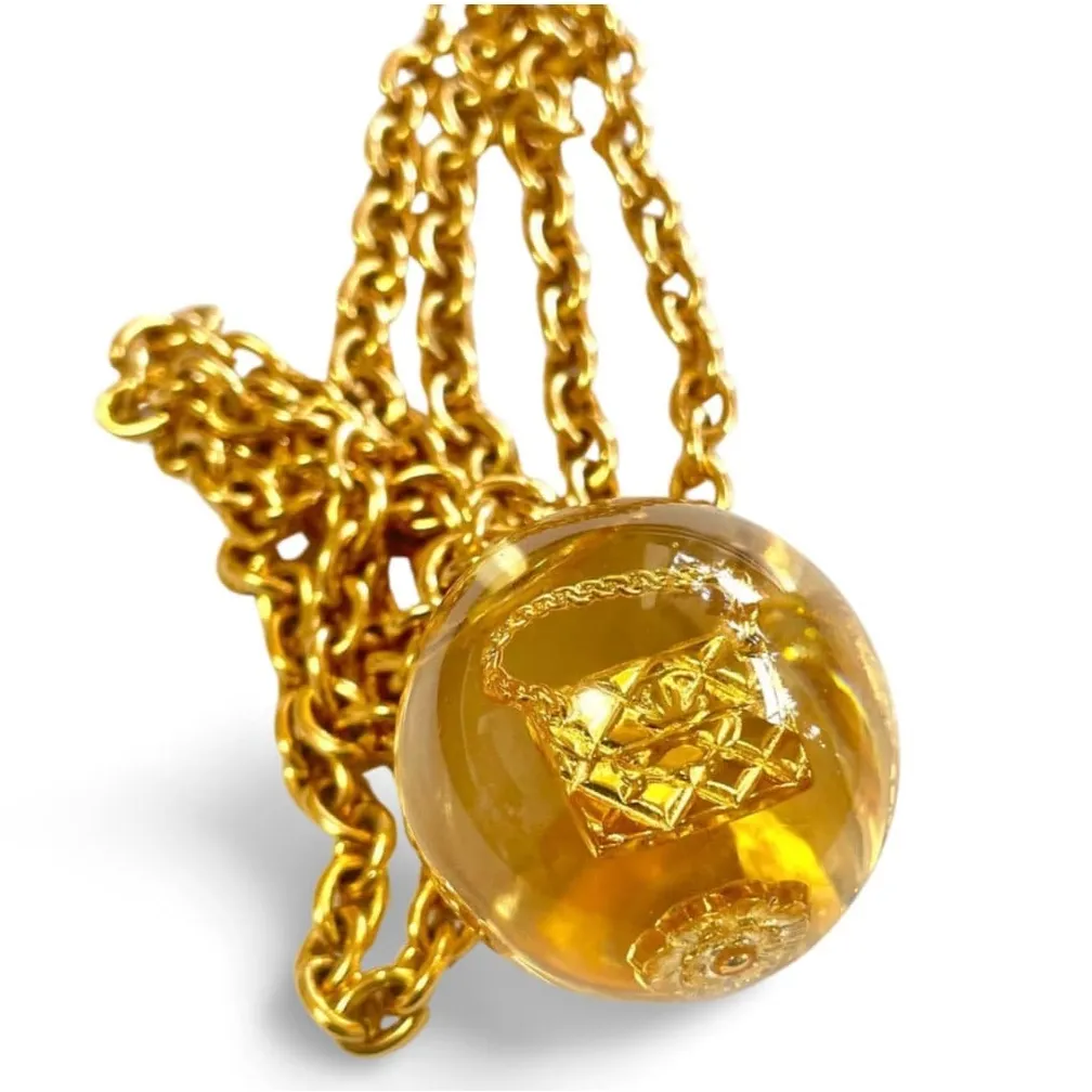 Vintage CHANEL long chain necklace with resin ball top, CC mark, turtle, camellia, clover, and 2.55 bag motifs in it. 060312ac4